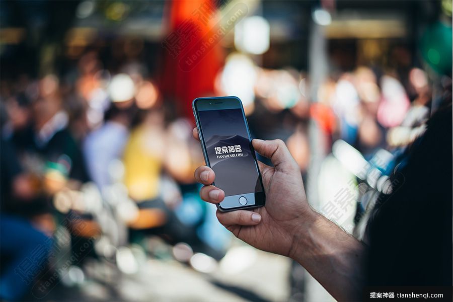 模糊人群背景男士手拿黑色iPhone6高清场景样机素材